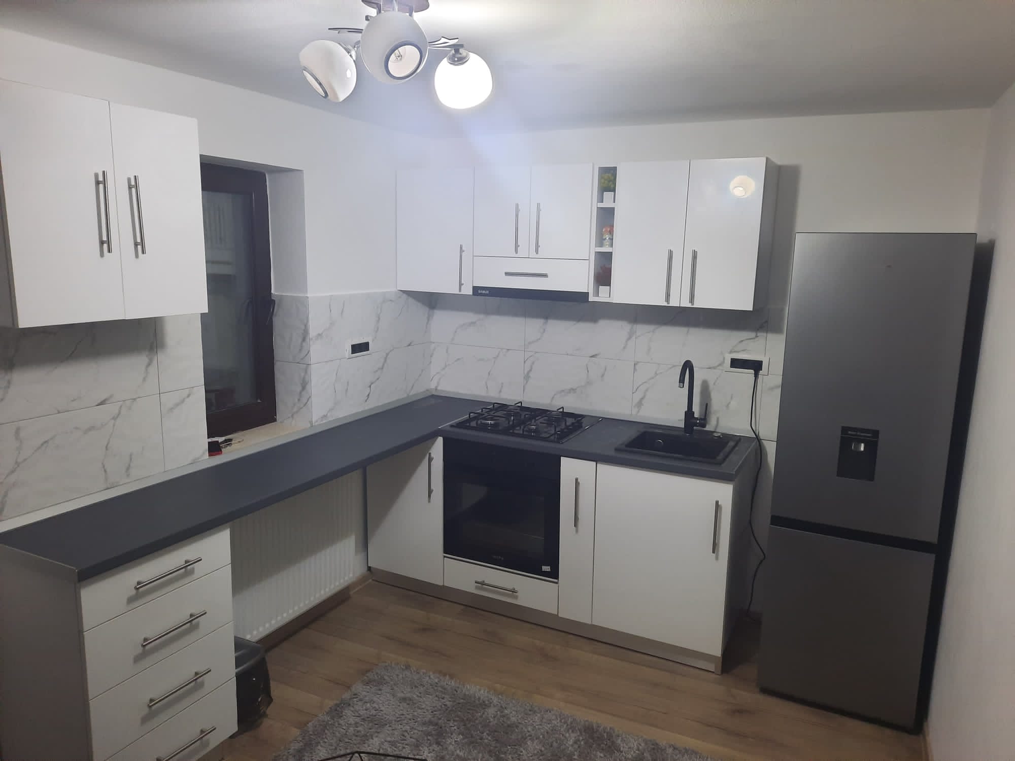 Bucătărie cu mobilier adaptat configurației încăperii.
